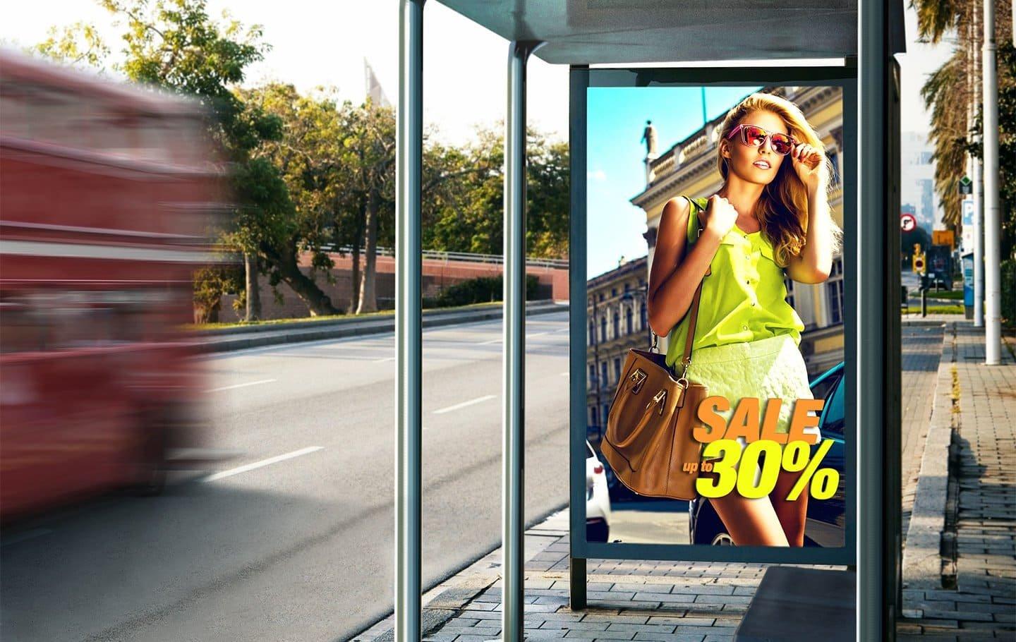 a bus stop with a poster advertising a sale on a woman's dress